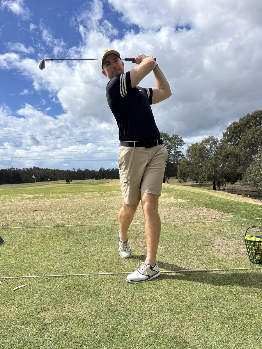 Mitch Potts finishing a golf swing on the range
